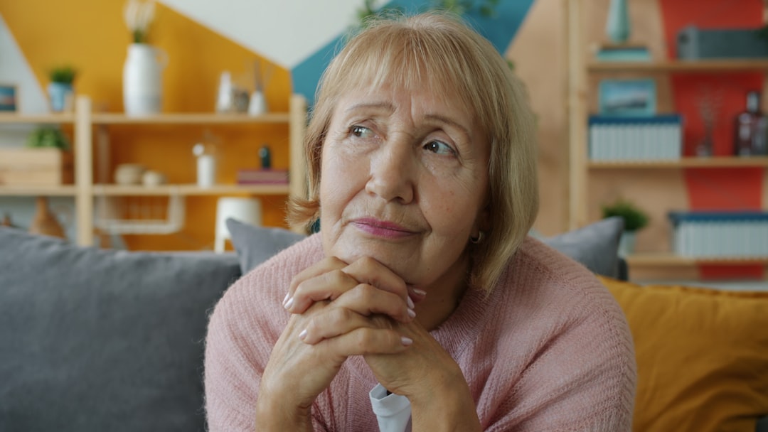 Older woman sitting thoughtfully at home